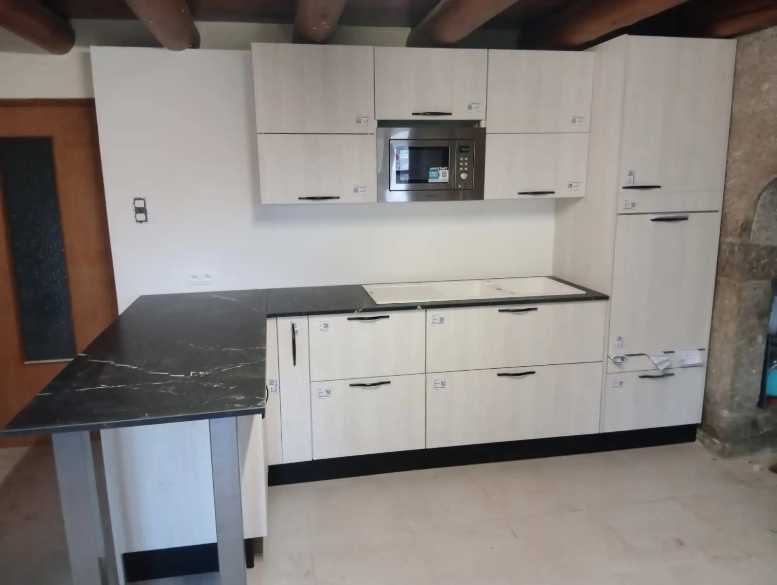 Après : cuisine installée avec meubles, plan de travail et électroménager intégrés